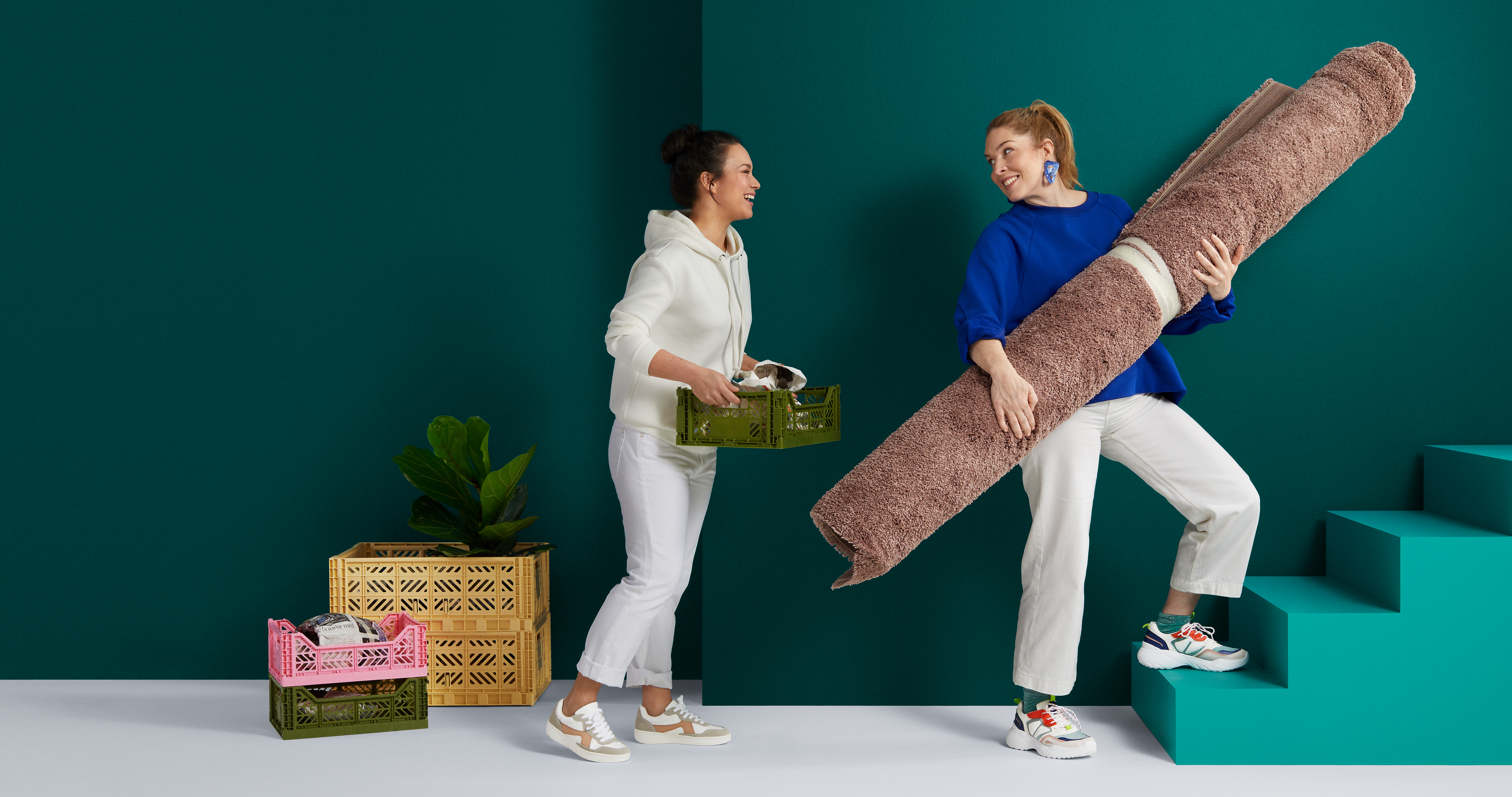 Två kvinnor flyttar inredning