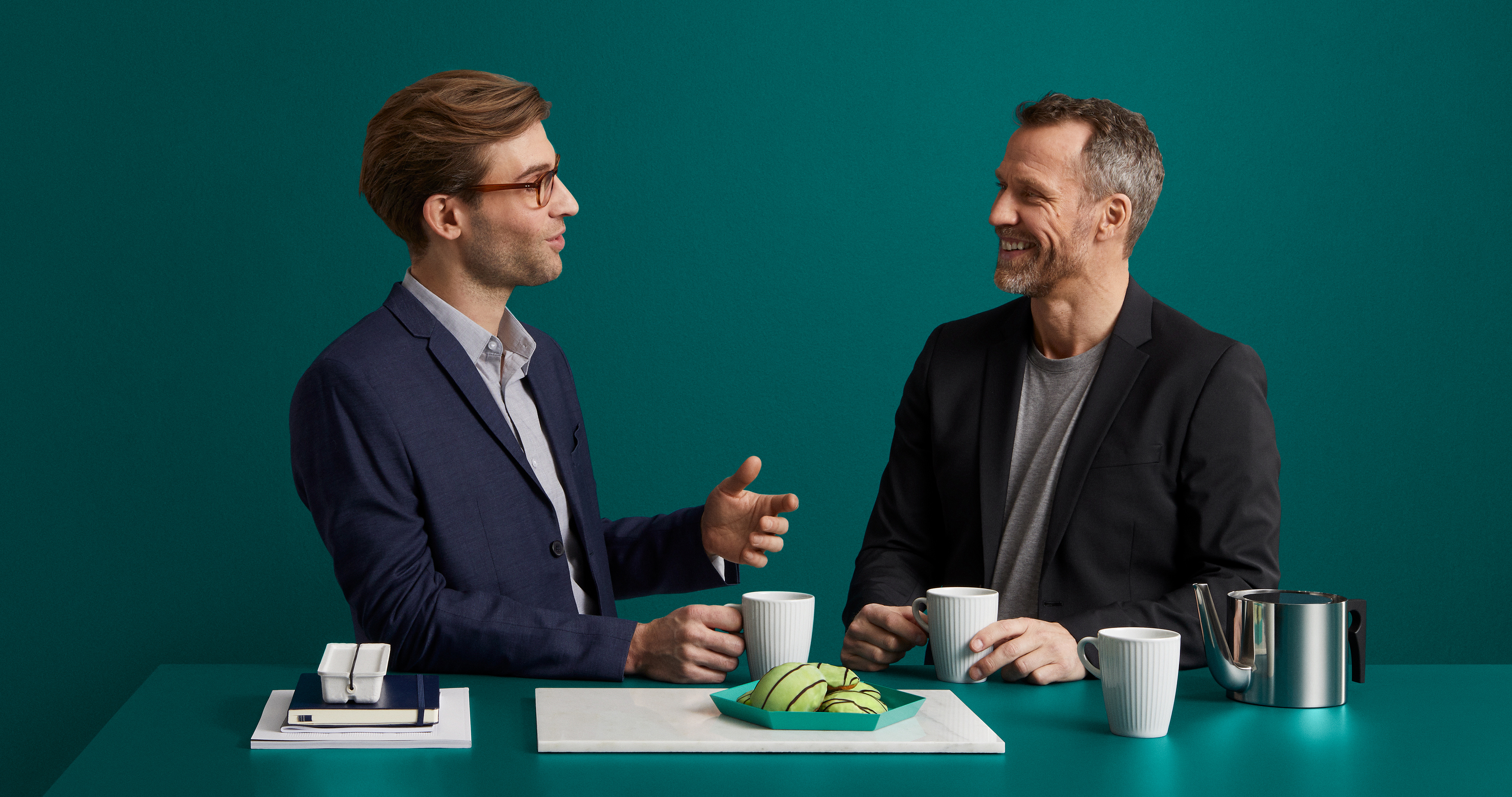 Arbetsplats Två men pratar vid fikabordet