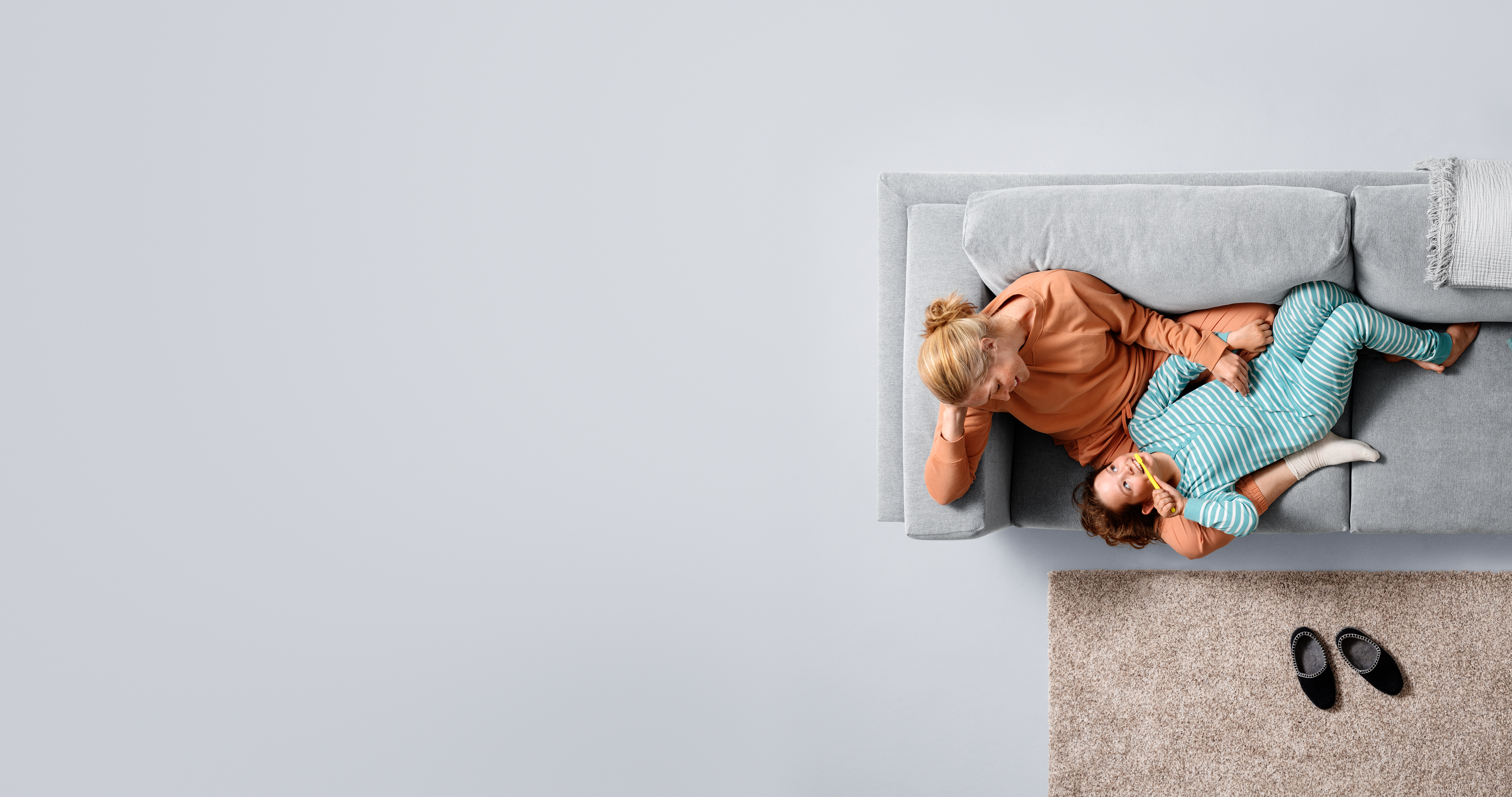 Familj Kvinna och barn sitter i soffa