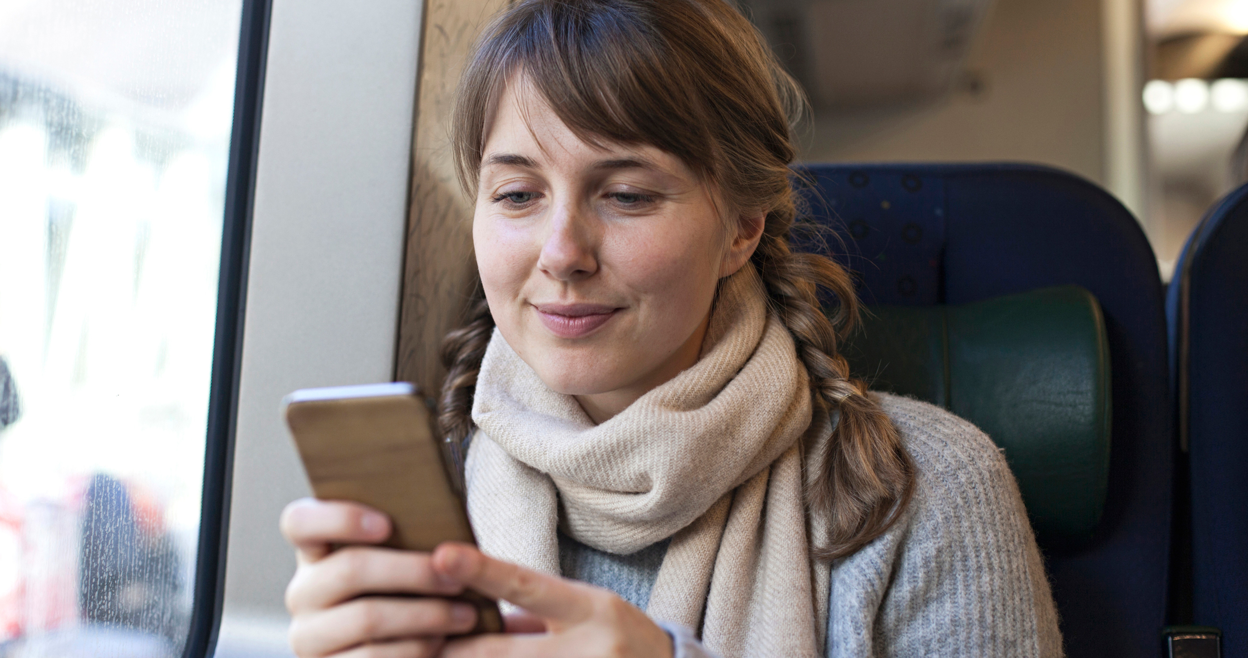 Kvinna ser över sitt sparande i mobil